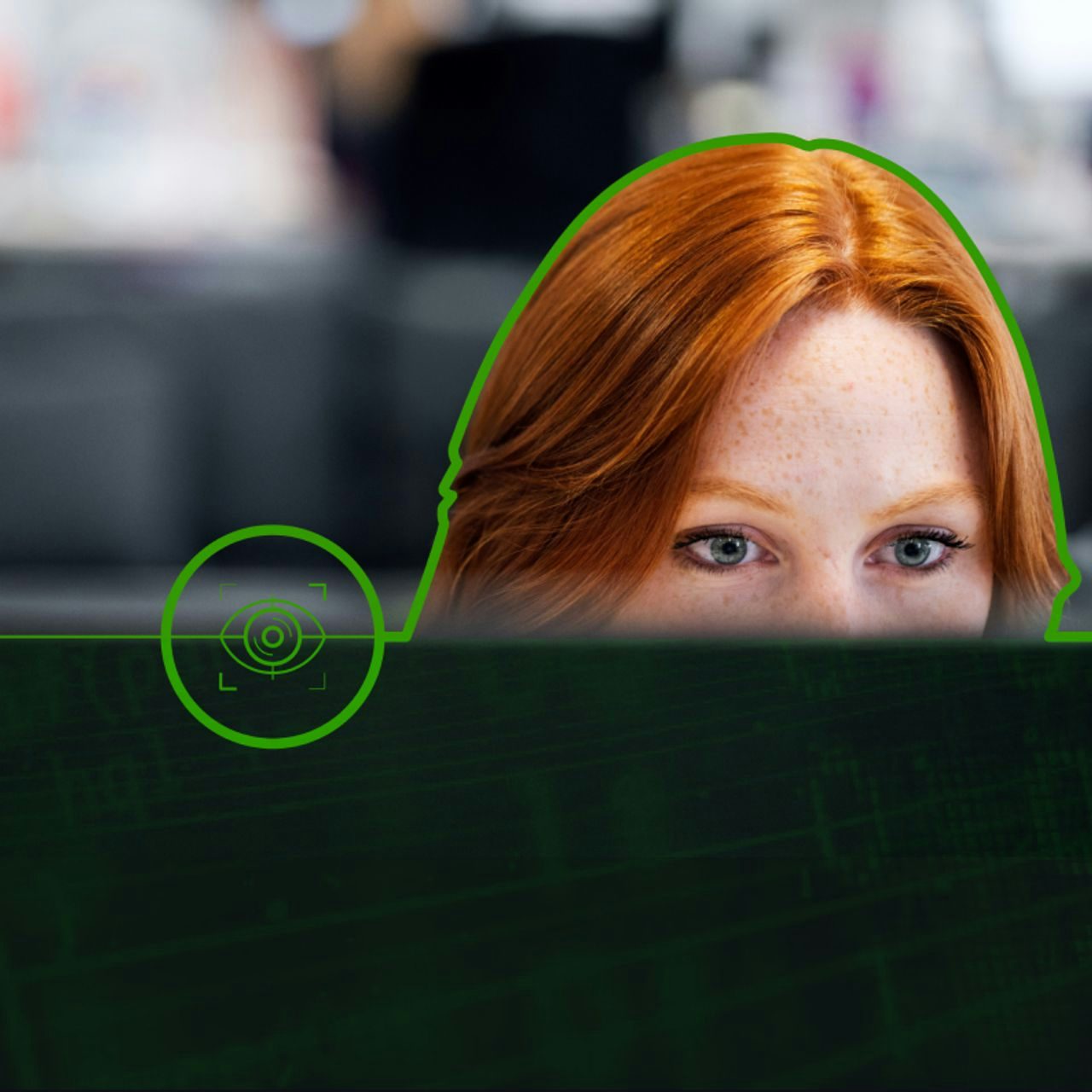 A focused woman with red hair peeking over a computer monitor, with a graphical overlay representing cyber security.