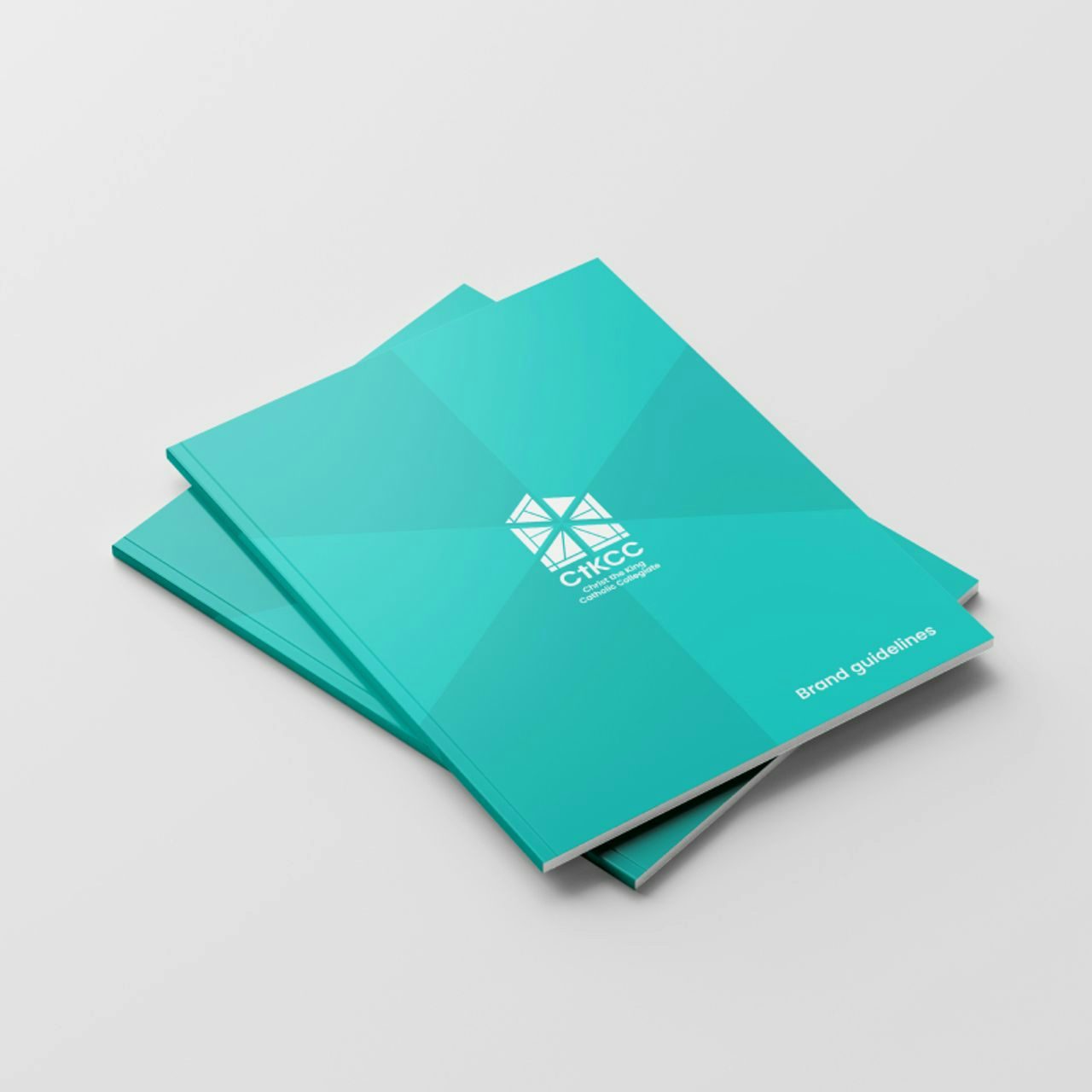 Two teal perfect-bound brochures with 'CtKCC Brand Guidelines' on the cover, set against a white background, showcasing corporate branding materials.