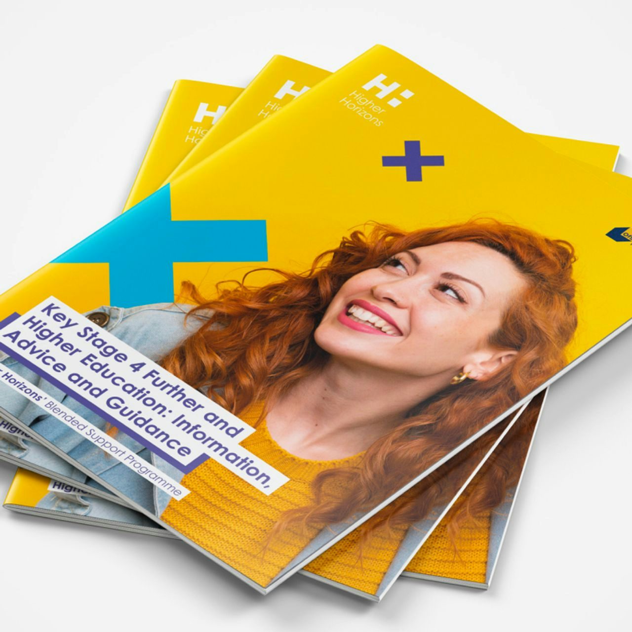 Stack of yellow educational brochures on Key Stage 4 and higher education advice, featuring a joyful red-haired woman.